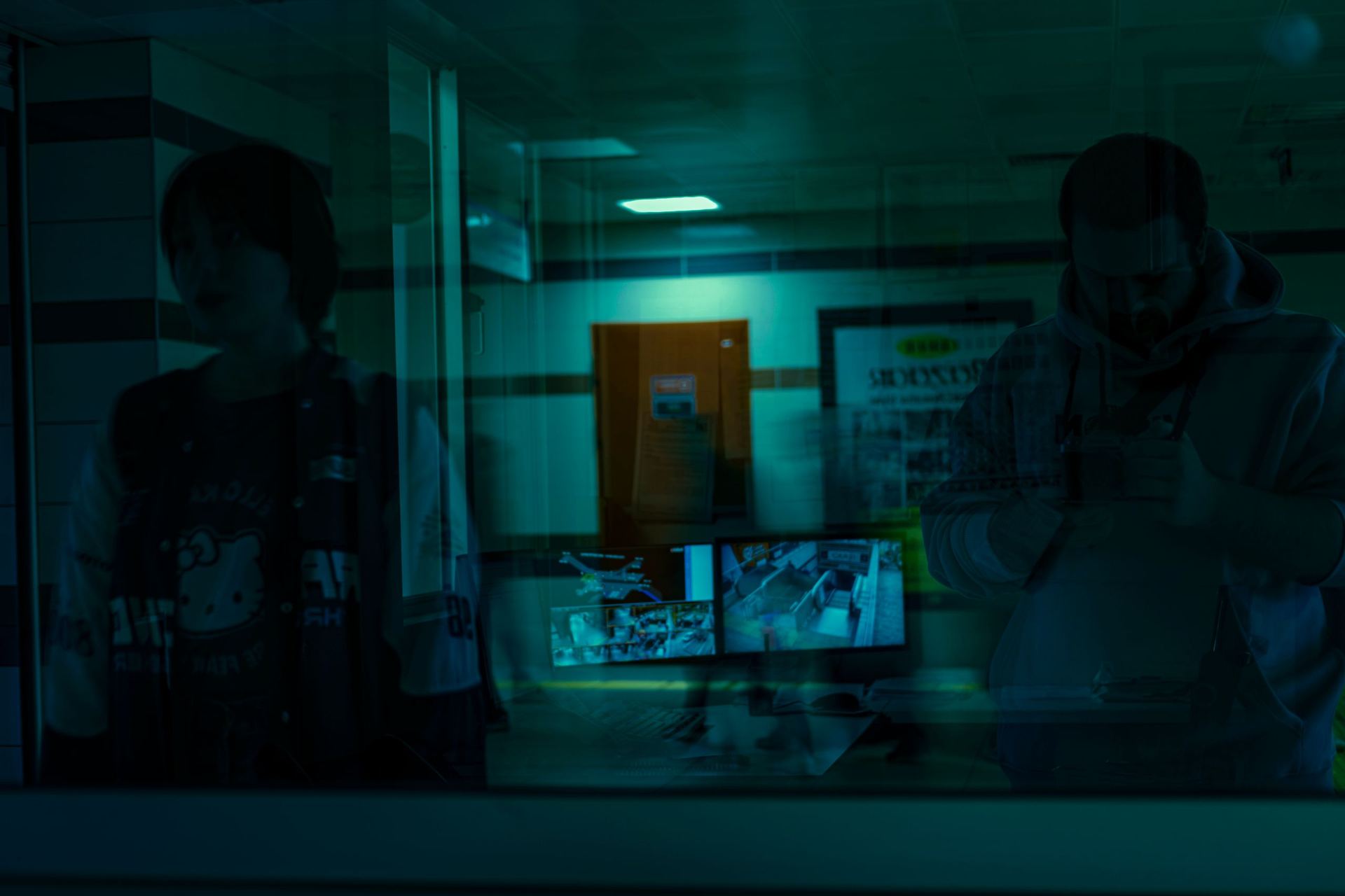 Operators monitoring a bank of camera feeds inside a security control room.