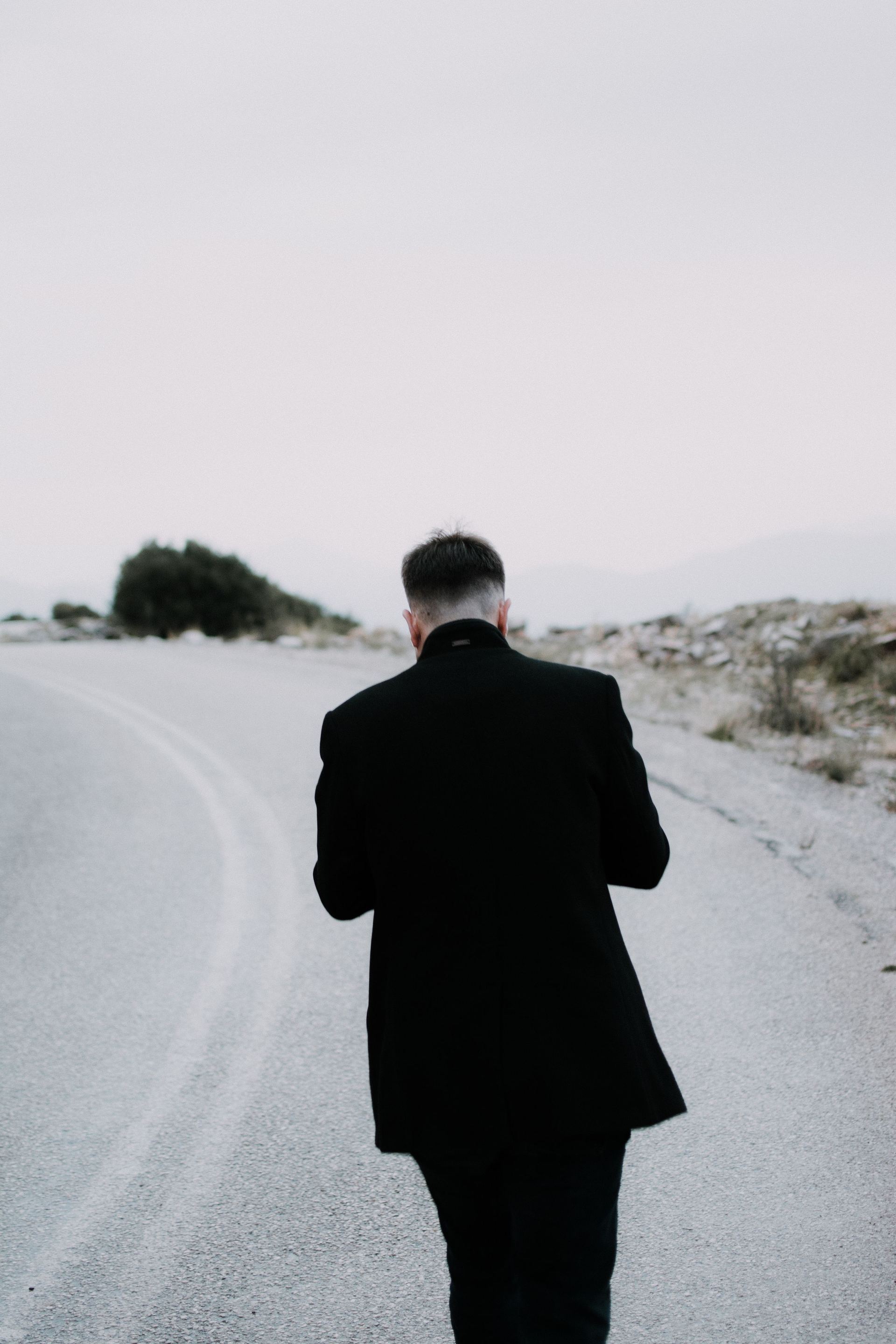 A close protection officer moving ahead of a principal on an open route.